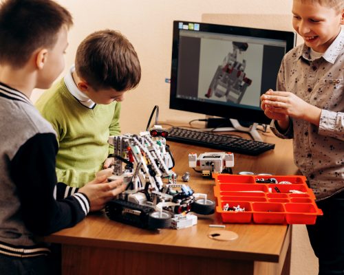 Three smart boys are making robots from the robotic constructor in the School of Robotics .